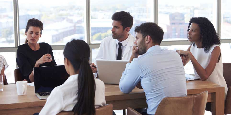 team meeting. colleagues at table with laptop computers out