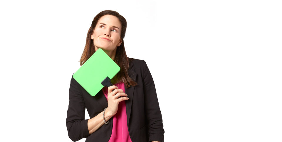 woman holding green dry-erase board under her chin