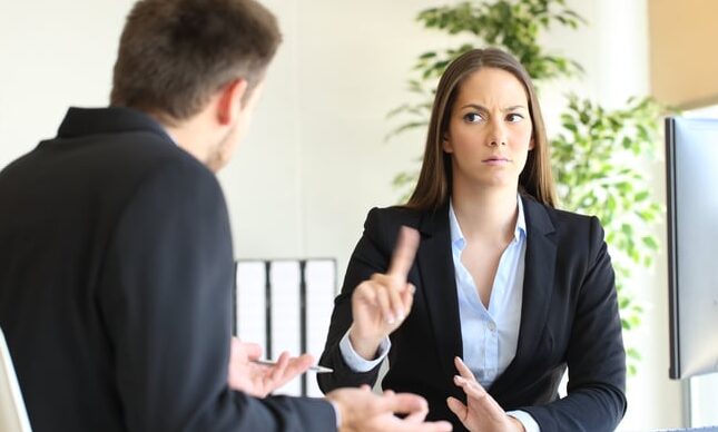 Female and male work colleagues having a difficult conversation