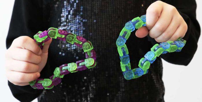 child holding two klix fidget toys