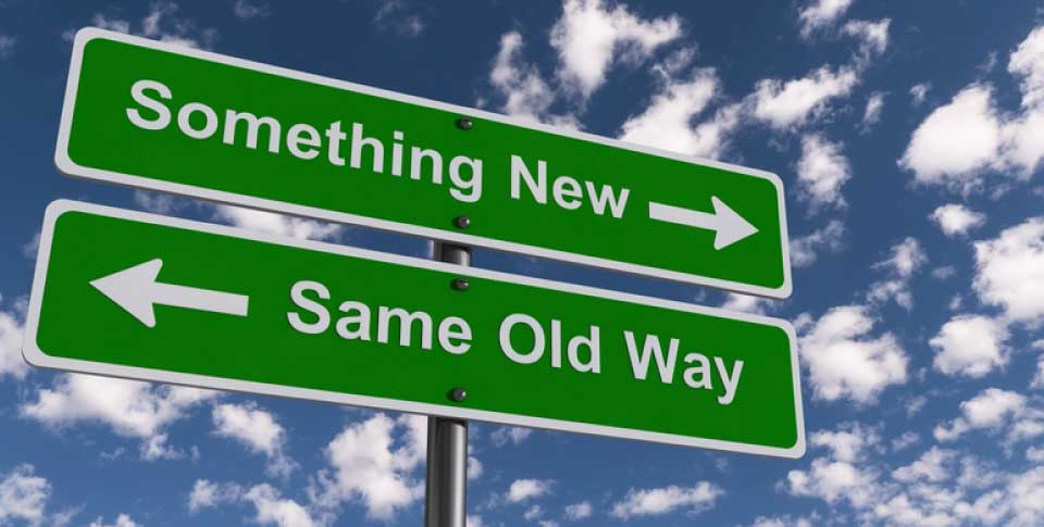 two road signs with arrows, against a background of clouds. one says something new; one says same old way