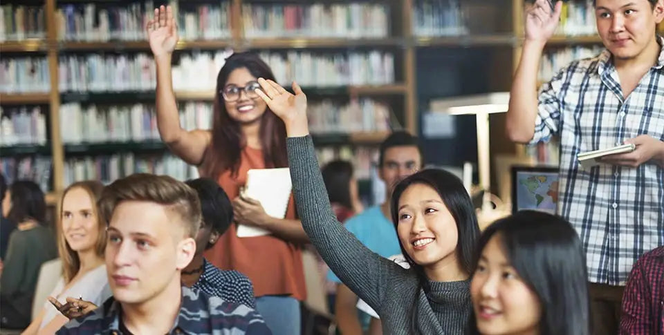 students raising hands, in a library setting
