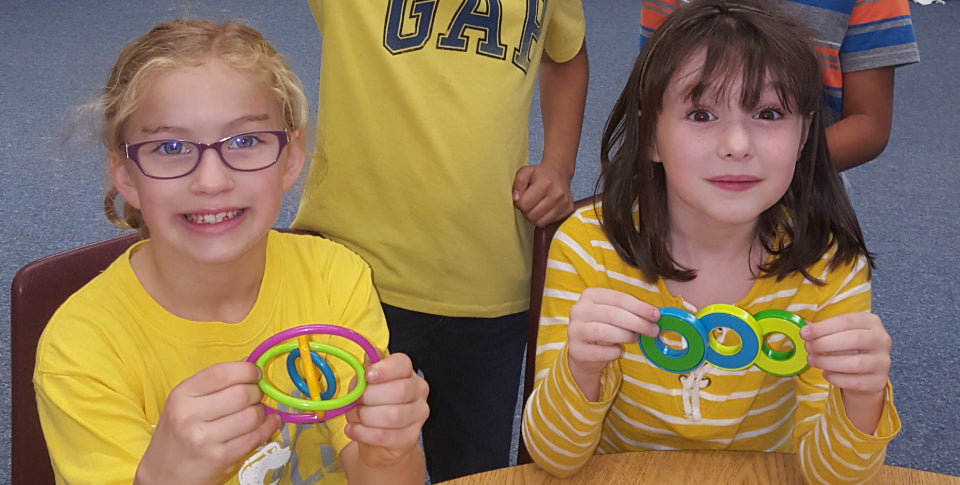 Children playing with gyrobi and swingos fidget toys