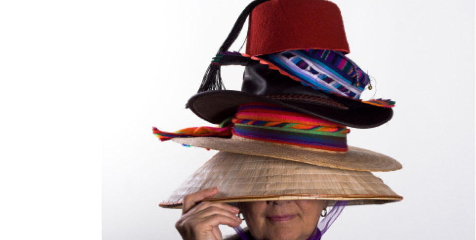 woman wears a stack of different hats