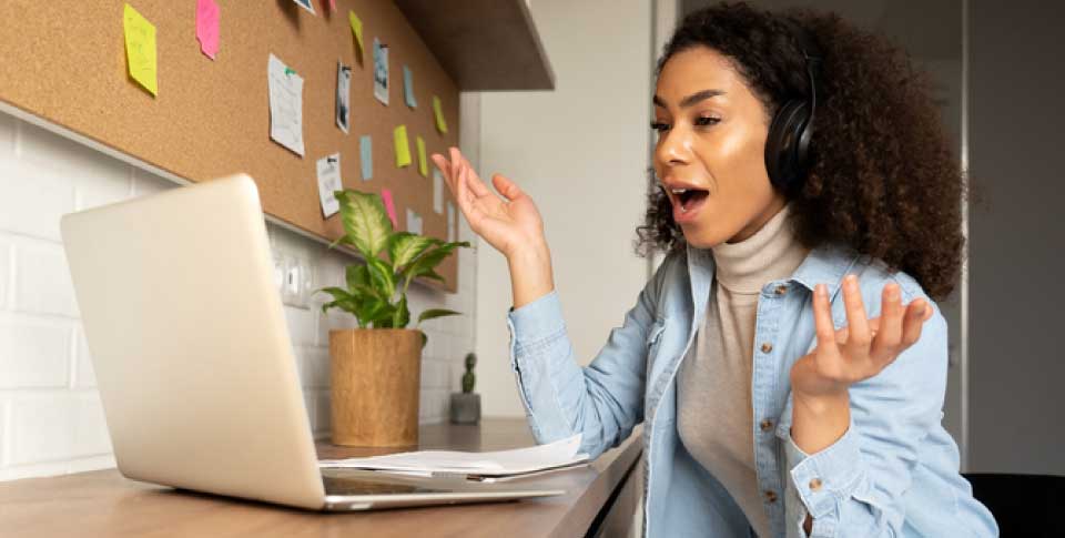 young worker in front of her laptop, participating in an online meeting