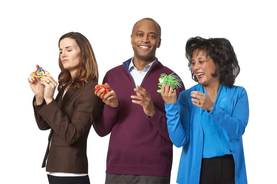 Three adults holding fidget toys