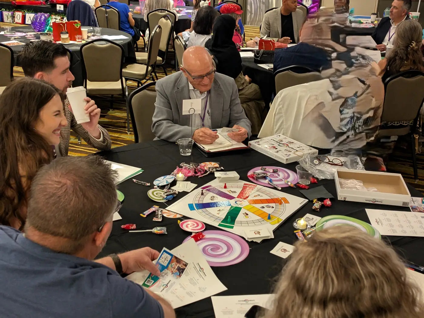 Diverse group of players play the company culture game at a table - Trainers Warehouse