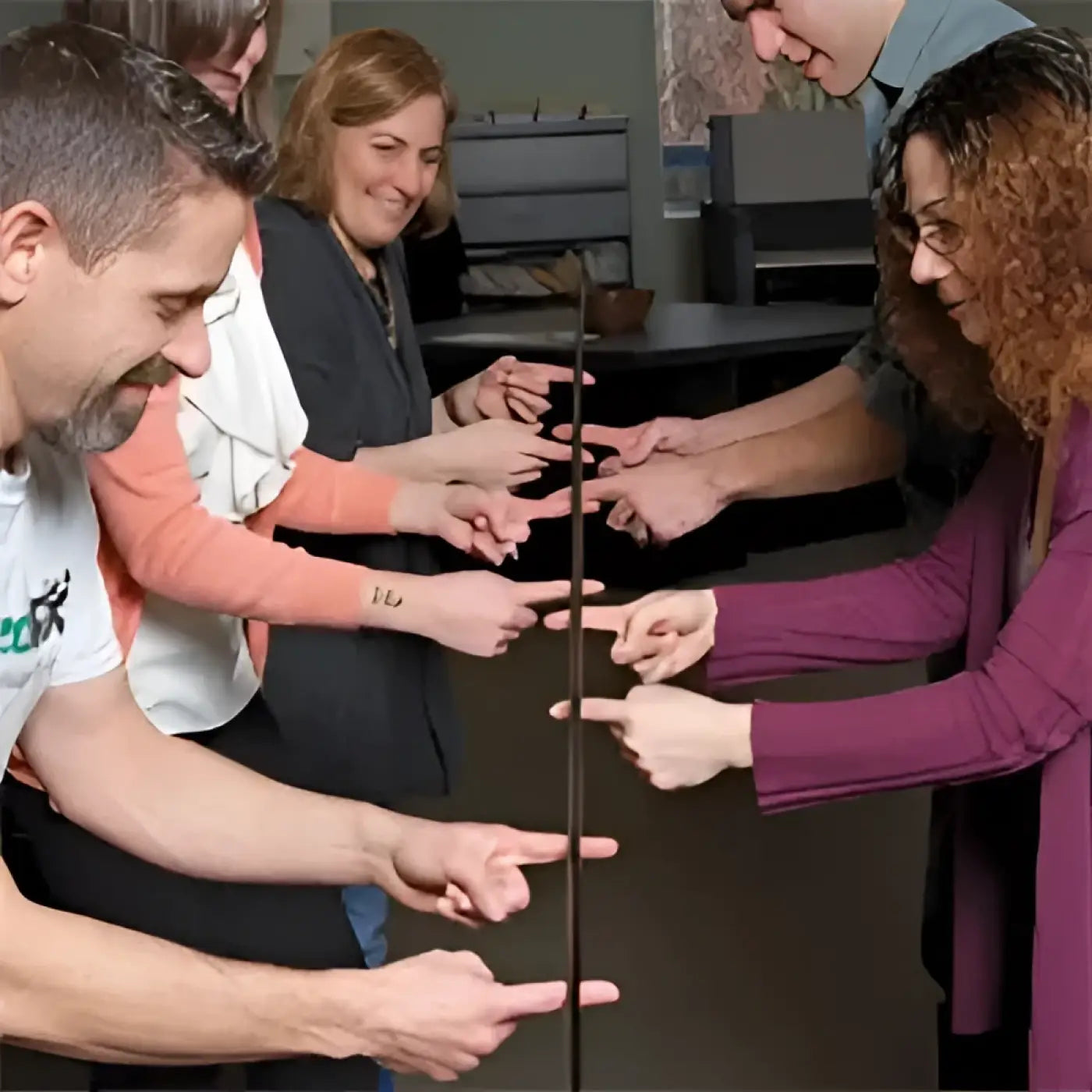 Helium Stick  - team players lowering the pole