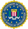 The seal of the department of justice, featuring a blue and gold emblem with an eagle clutching a shield.