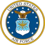 United states air force emblem featuring a golden eagle with outstretched wings above a blue shield adorned with white stars and an orange sunburst, encircled by gold lettering on a dark background.