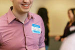Man wearing We Connect name tag with answer to the question "I am trying to solve the challenge of..."